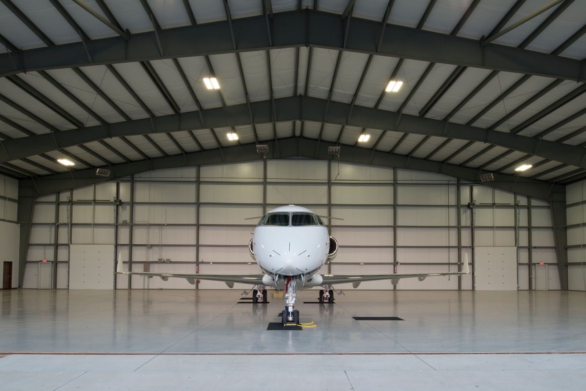 Private jet inside a pre-engineered steel airplane hangar with wide clear-span framing